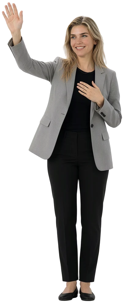 Una mujer rubia de blazer gris saluda con el brazo en alto.